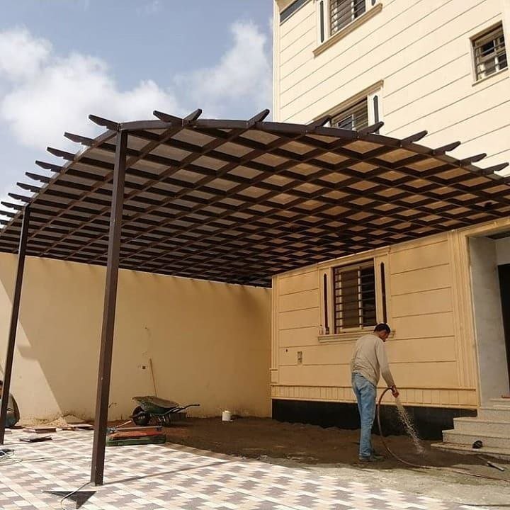 تنفيذ جلسة حوش عائلية ببرجولة خشبية ومقاعد مدمجة بمدينة عنك
